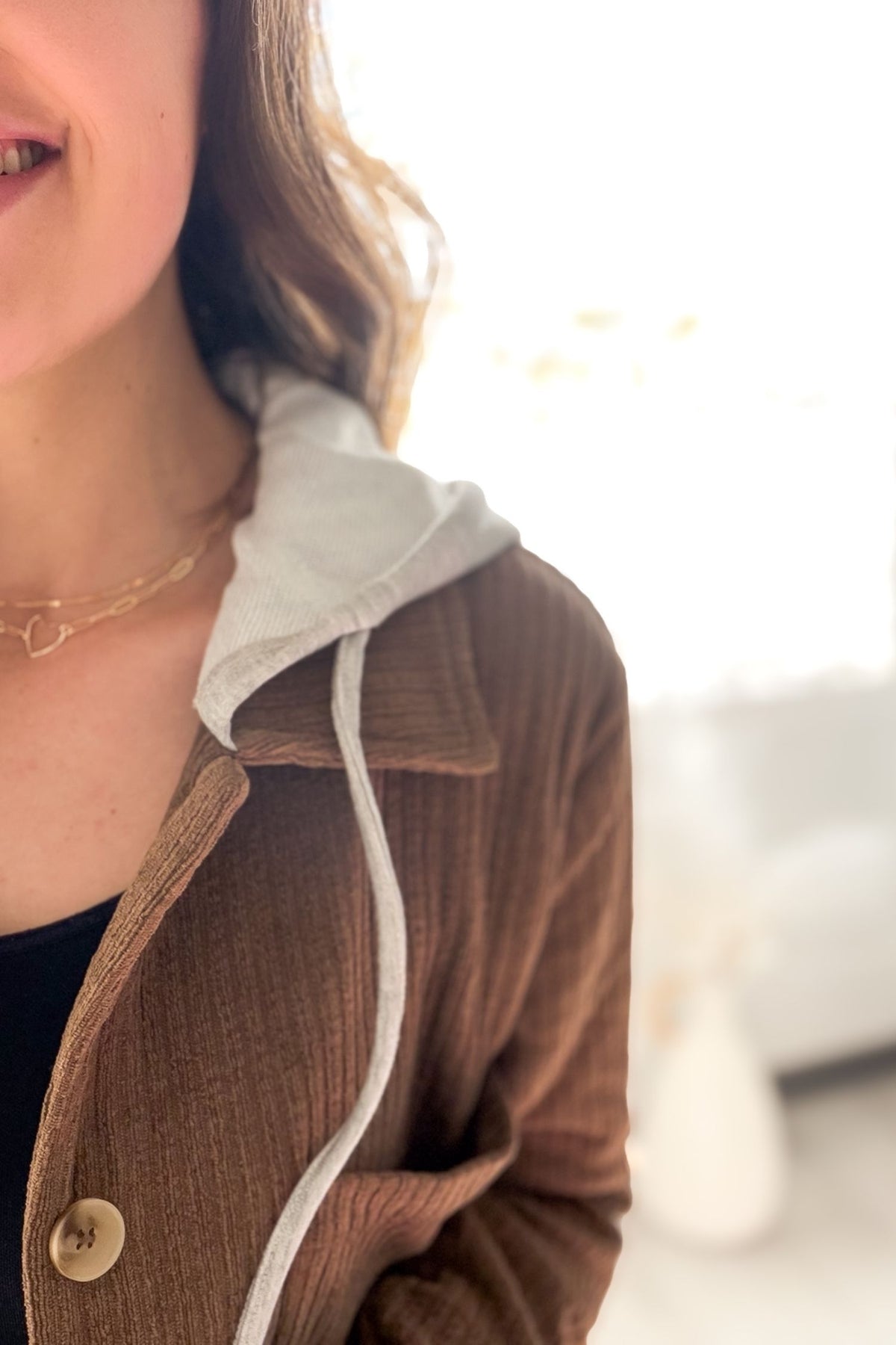 Close-up of a person wearing a brown jacket with a white hood.