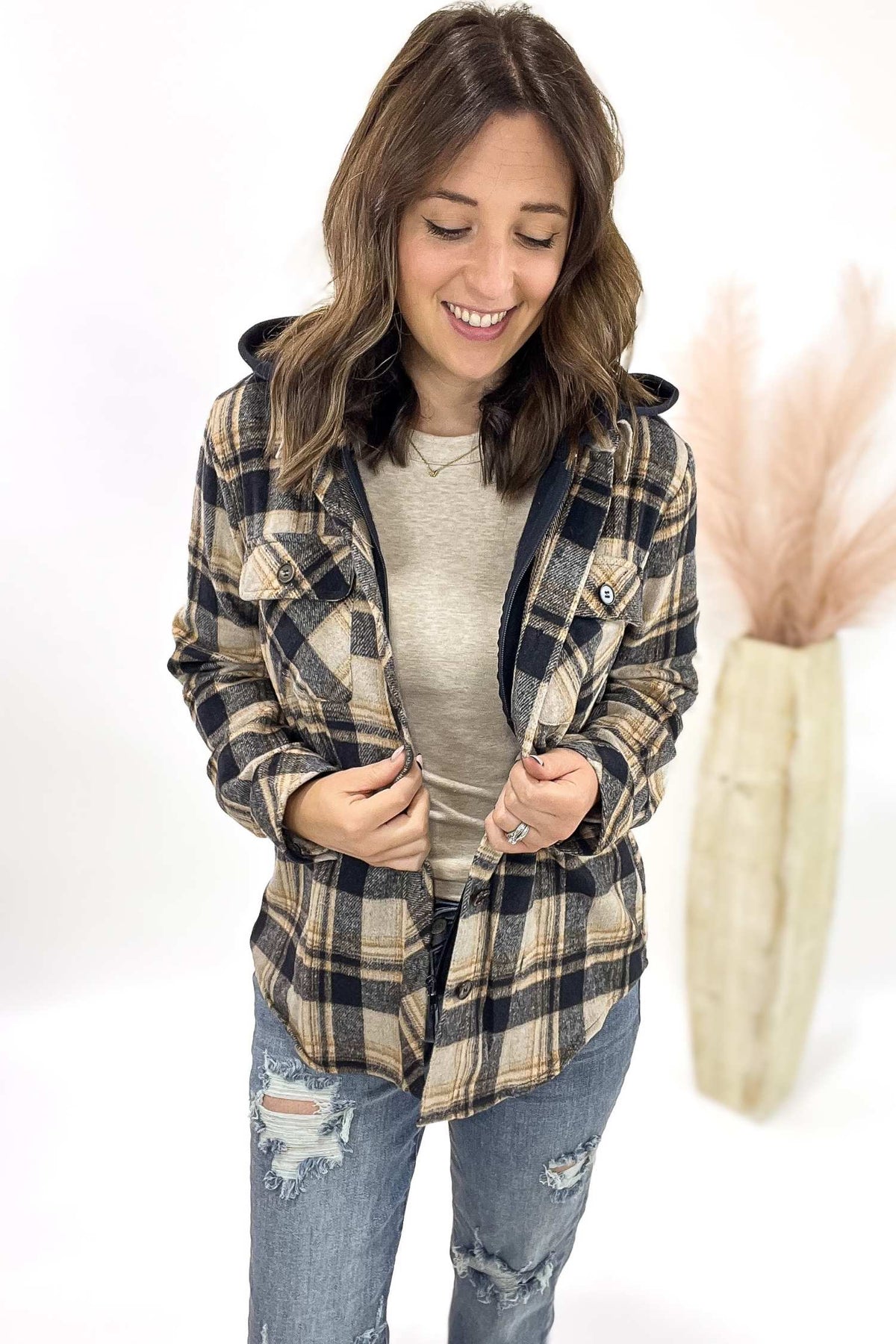 Woman wearing a plaid jacket and jeans on a white background