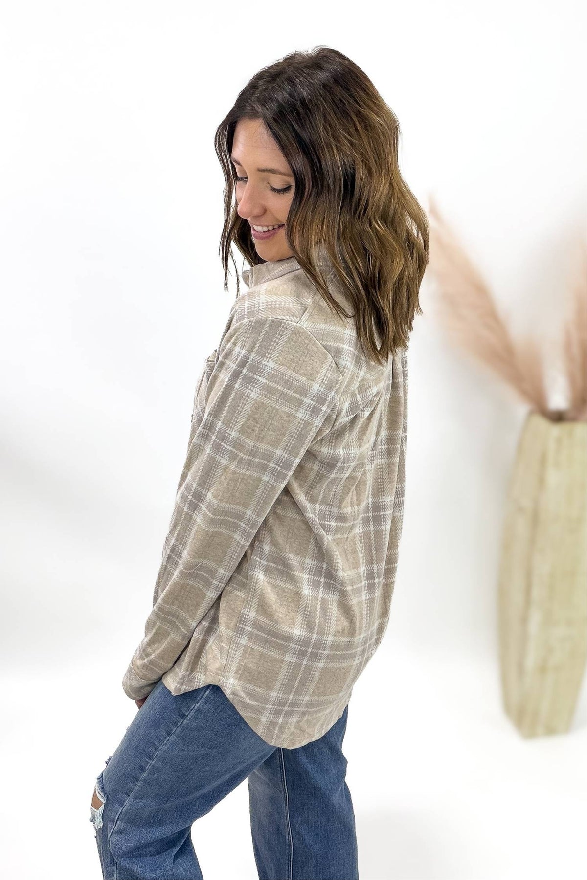 Woman wearing a plaid shirt and jeans on a white background