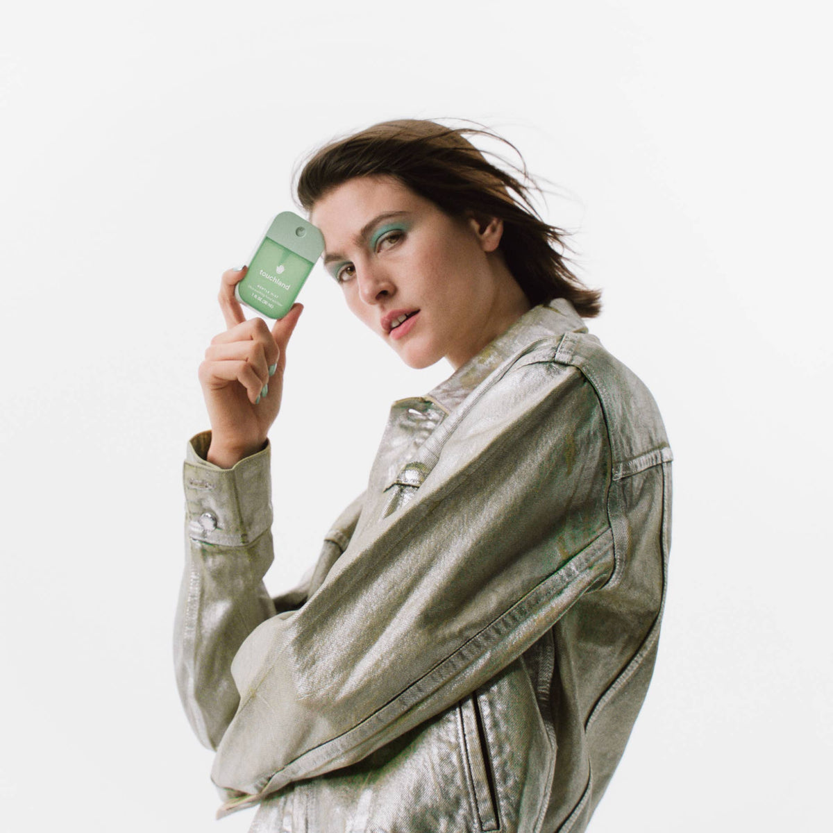 Woman holding a green bottle with a white background