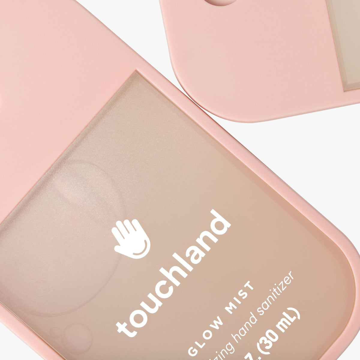 Pink hand sanitizer container with 'touchland' branding on a white background