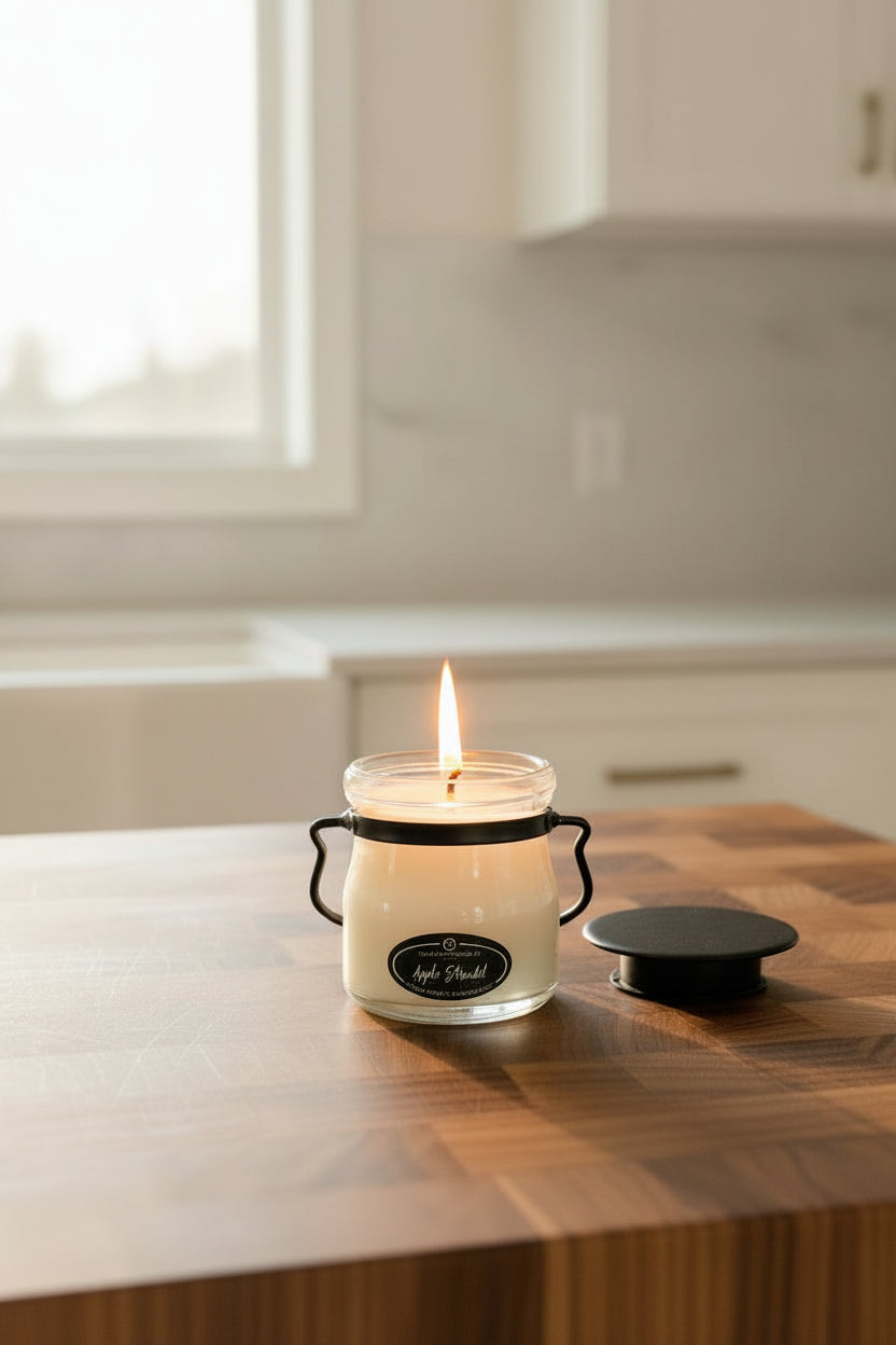 Apple strudle candle sitting on. awood cutting board in a kitchen