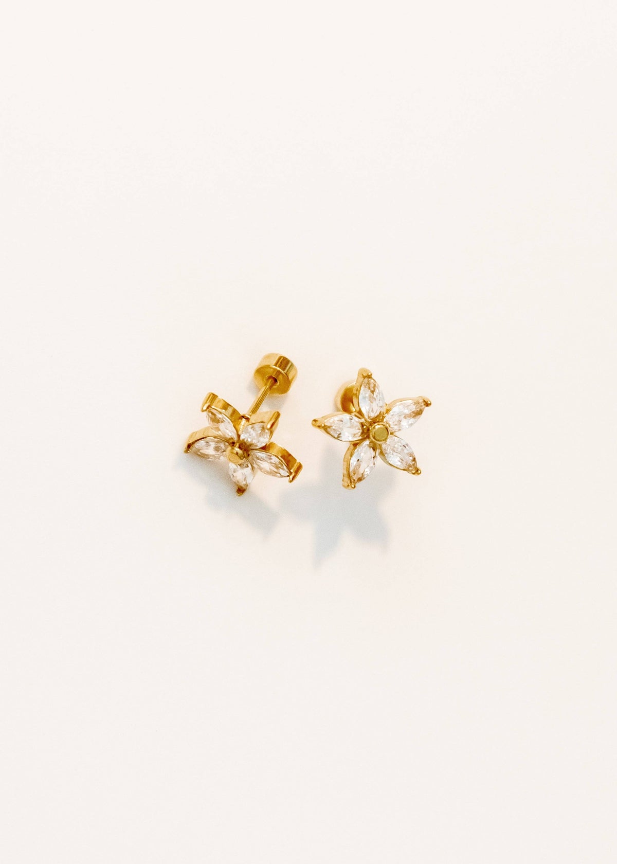 Gold butterfly-shaped earrings on a light gray background
