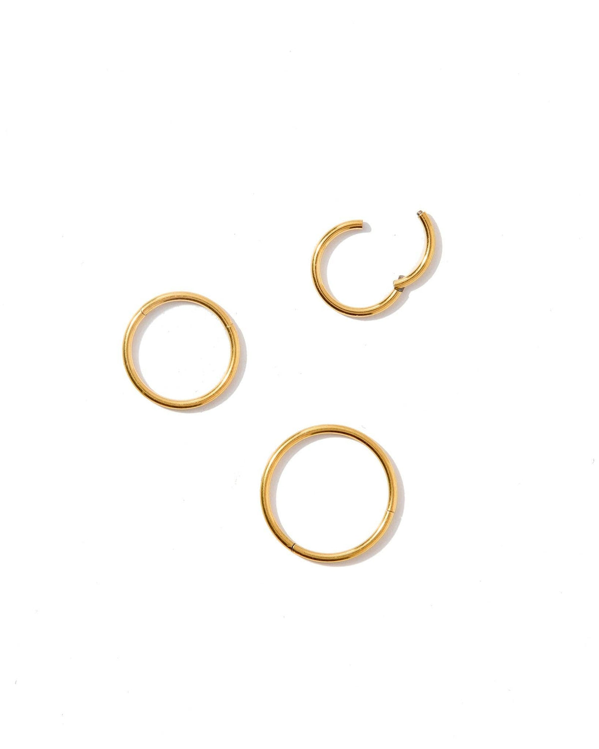 Set of gold hoop earrings on a white background