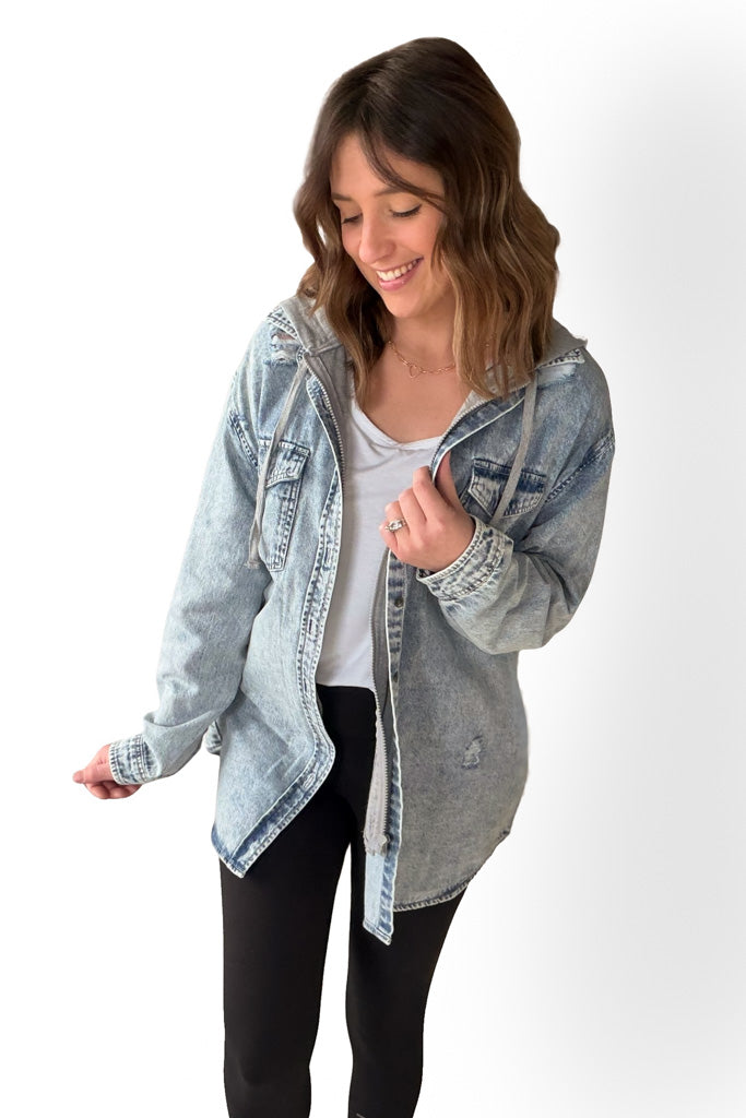 Woman wearing a light blue denim jacket on a white background