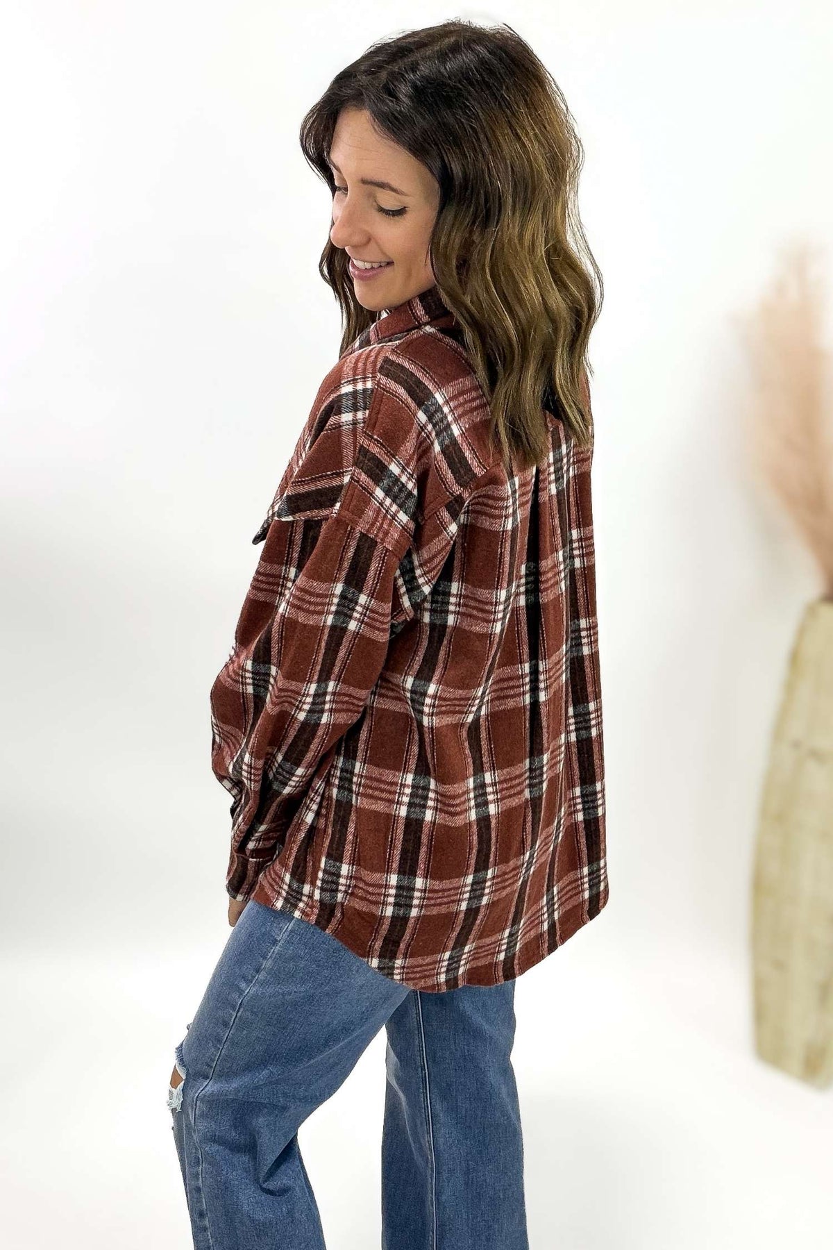 Woman wearing a plaid shirt and jeans on a white background