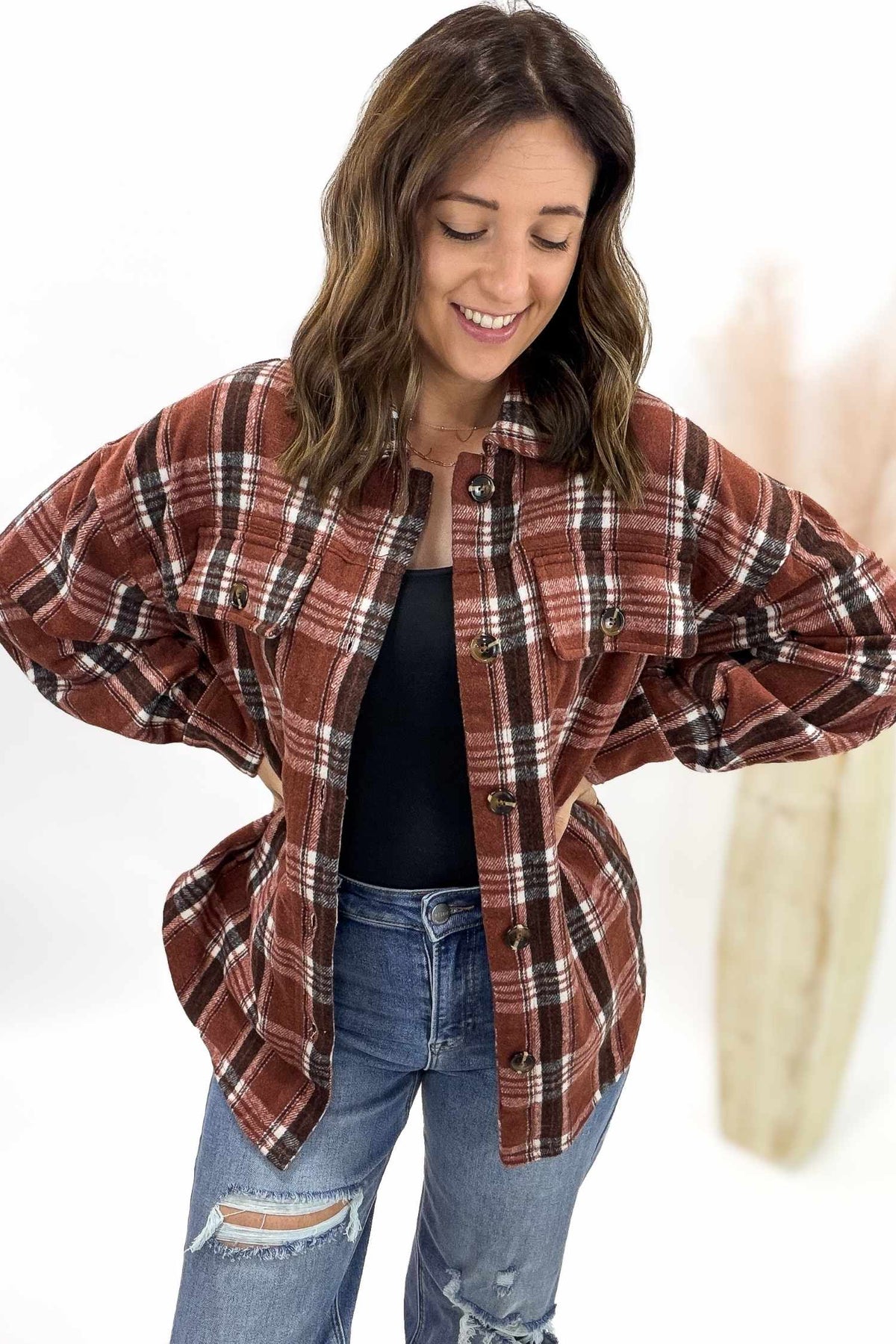 Woman wearing a plaid jacket and jeans on a white background