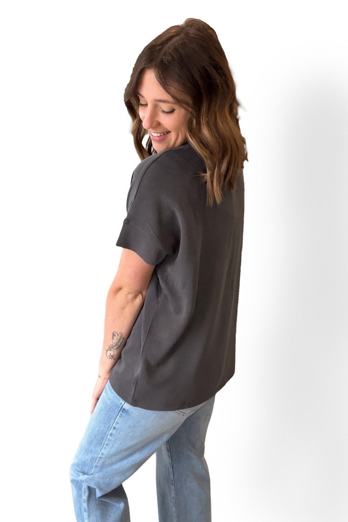 Woman wearing a gray t-shirt and blue jeans on a white background