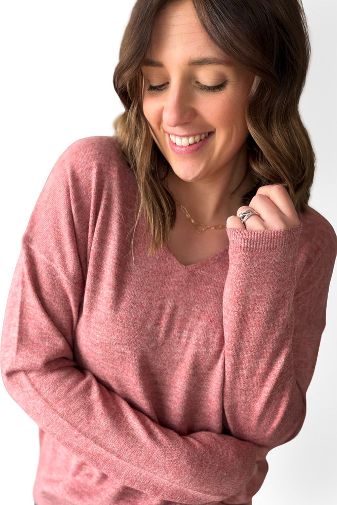 Woman wearing a berry sweater on a white background