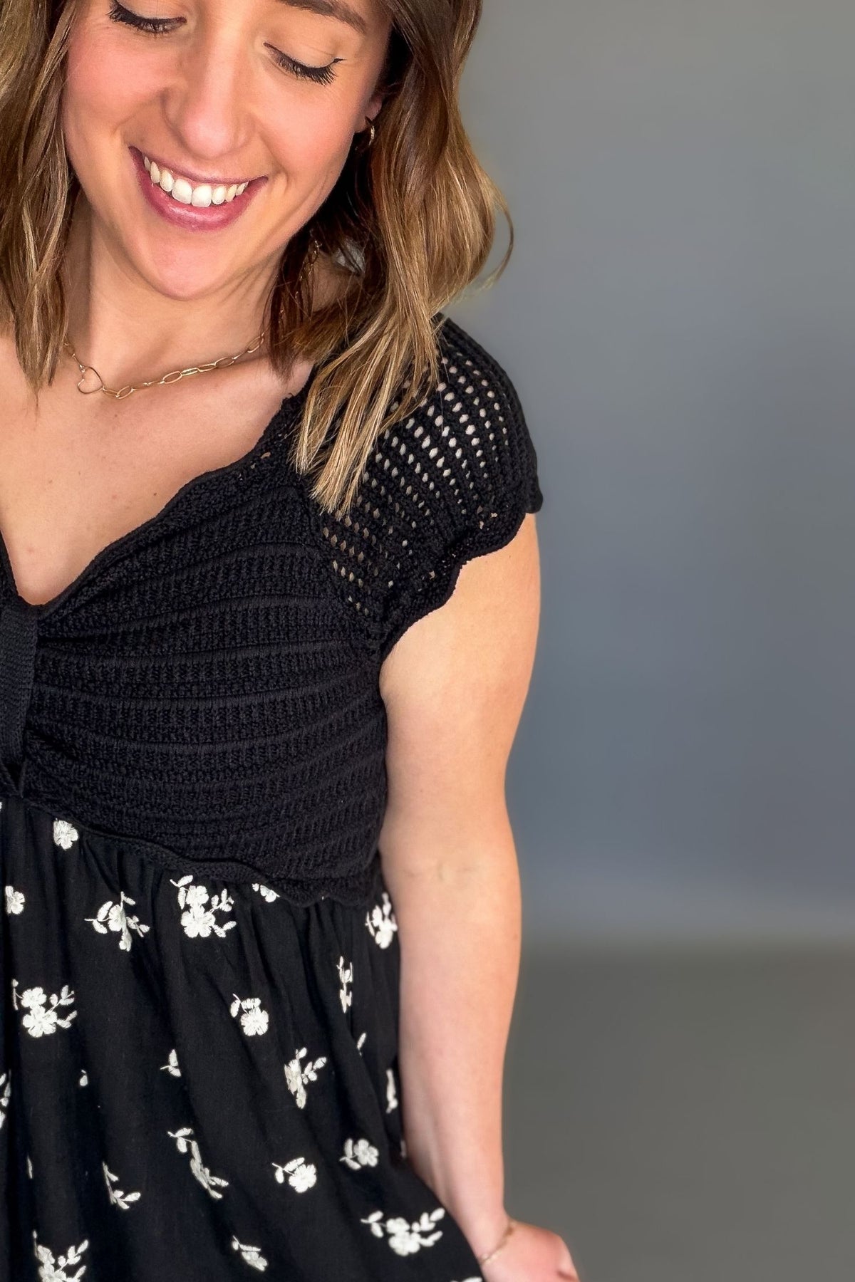 woman wearing a black crochet top midi dress showing up close details
