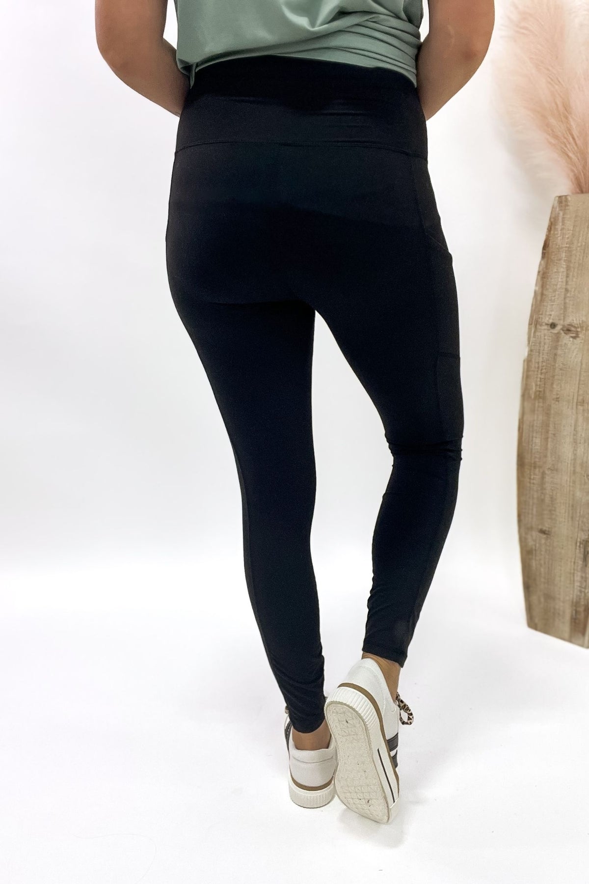 Person wearing black leggings on a white background