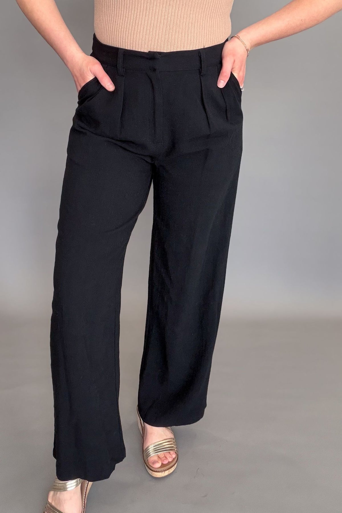Person wearing black pants on a gray background