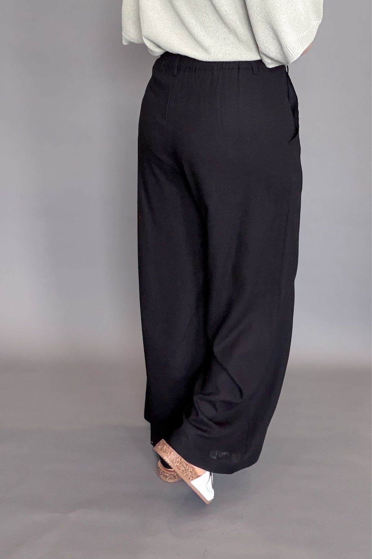 woman wearing a black linen blend wide leg work pant showing back details