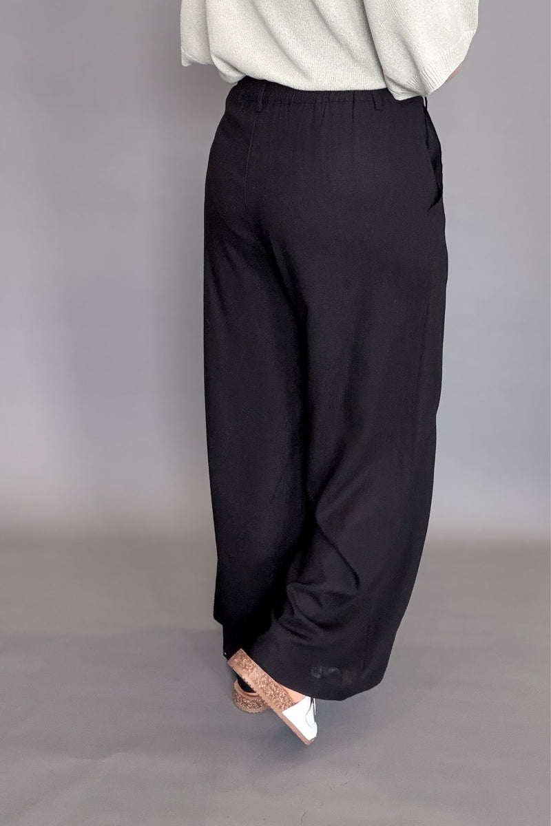 woman wearing a black linen blend wide leg work pant showing back details