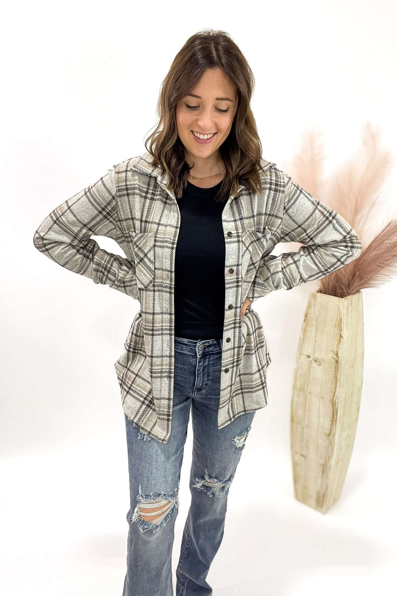 Woman wearing a plaid shirt and jeans with a white background