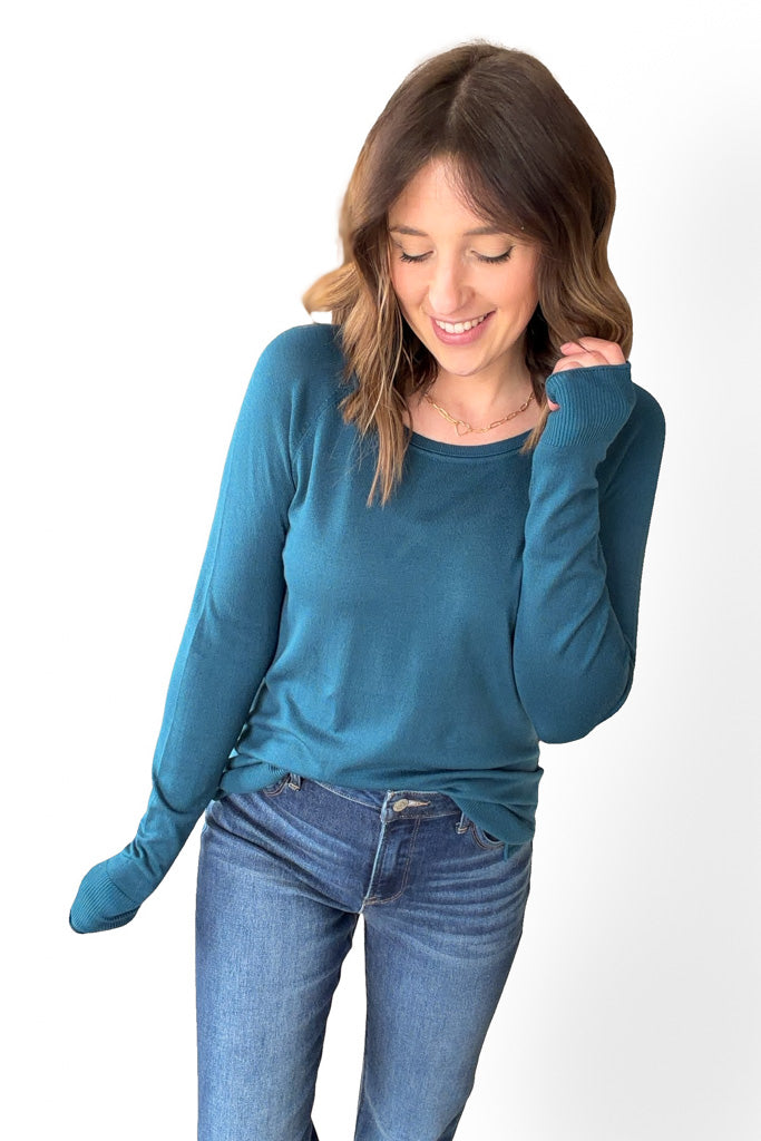 Woman wearing a blue sweater and jeans on a white background
