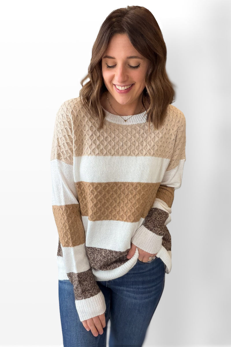 Woman wearing a striped sweater with a plain background