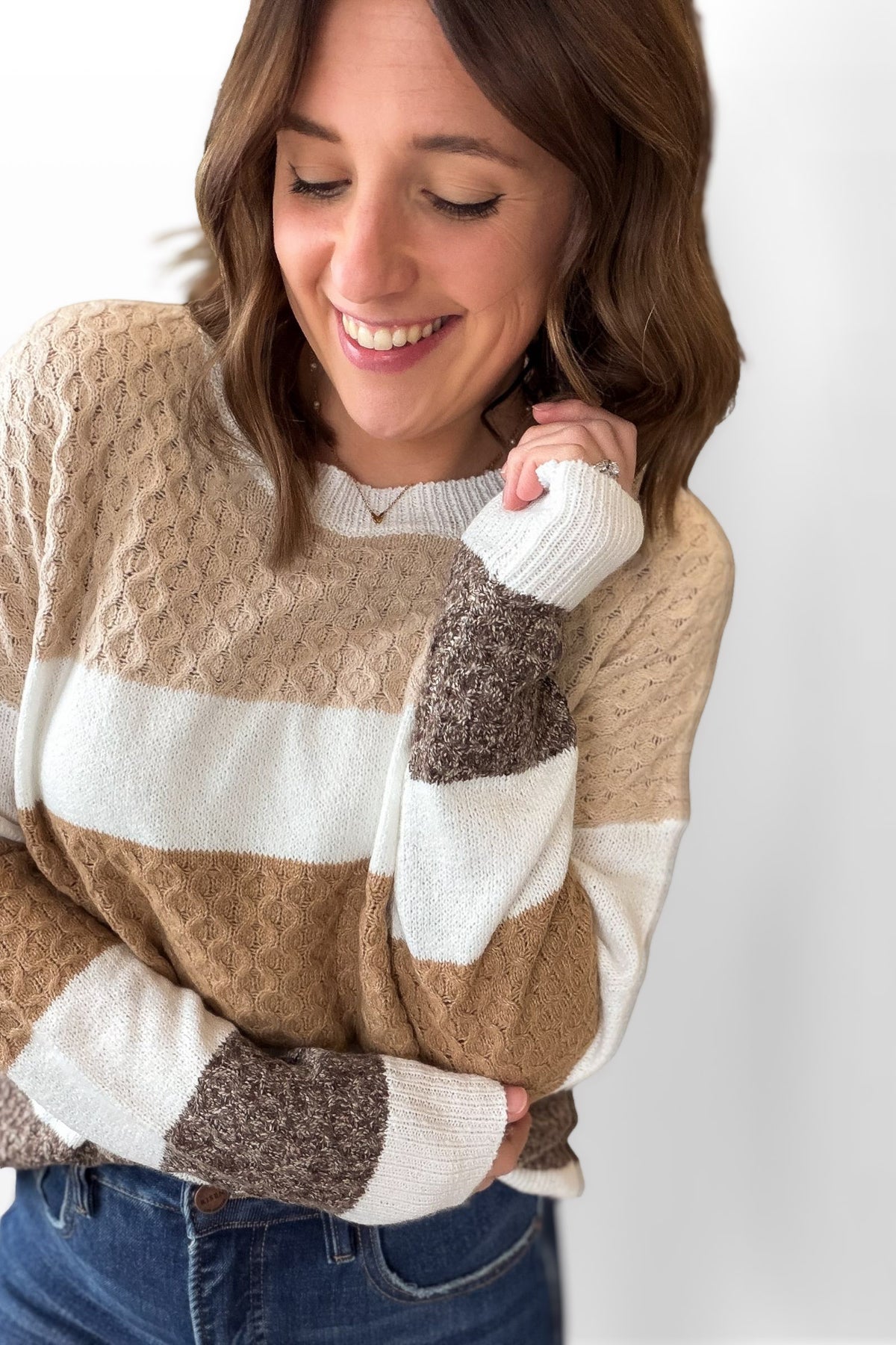 Woman wearing a striped sweater with a plain background