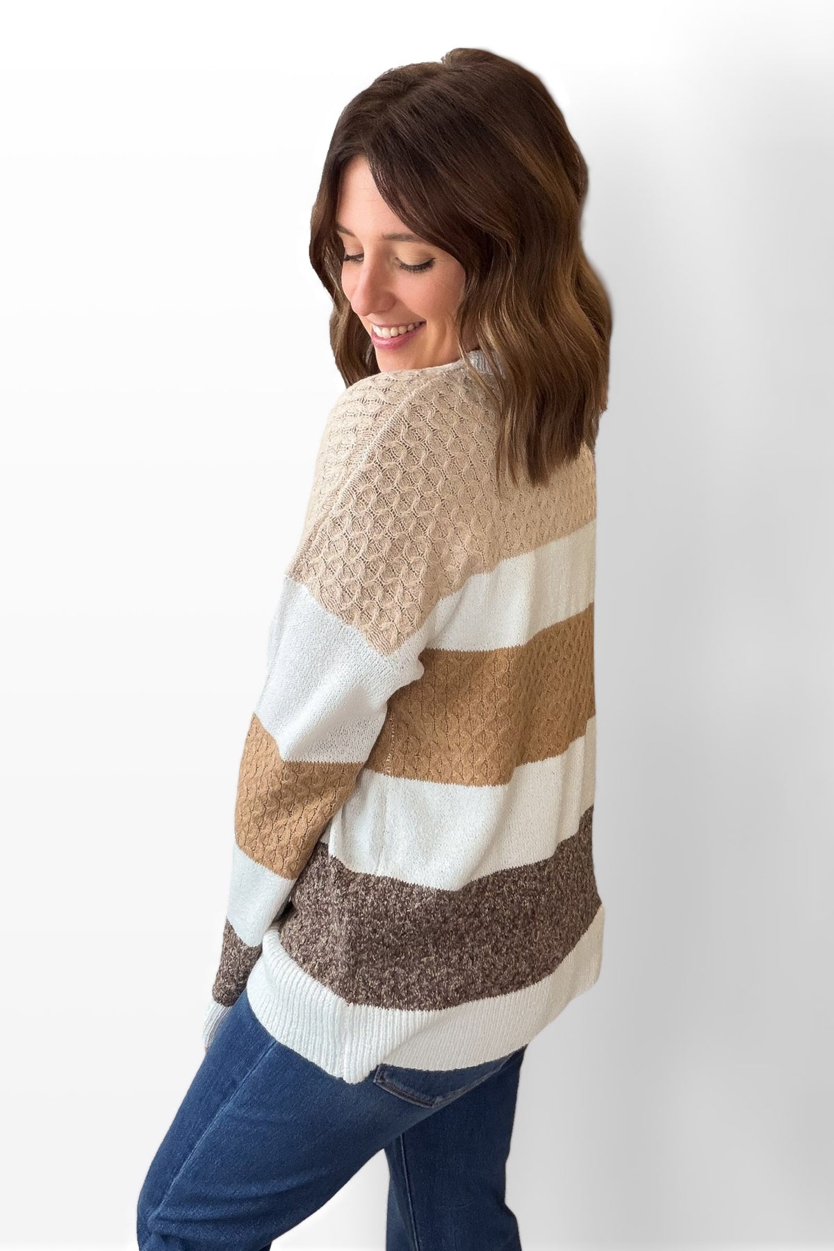 Woman wearing a striped sweater with a plain background