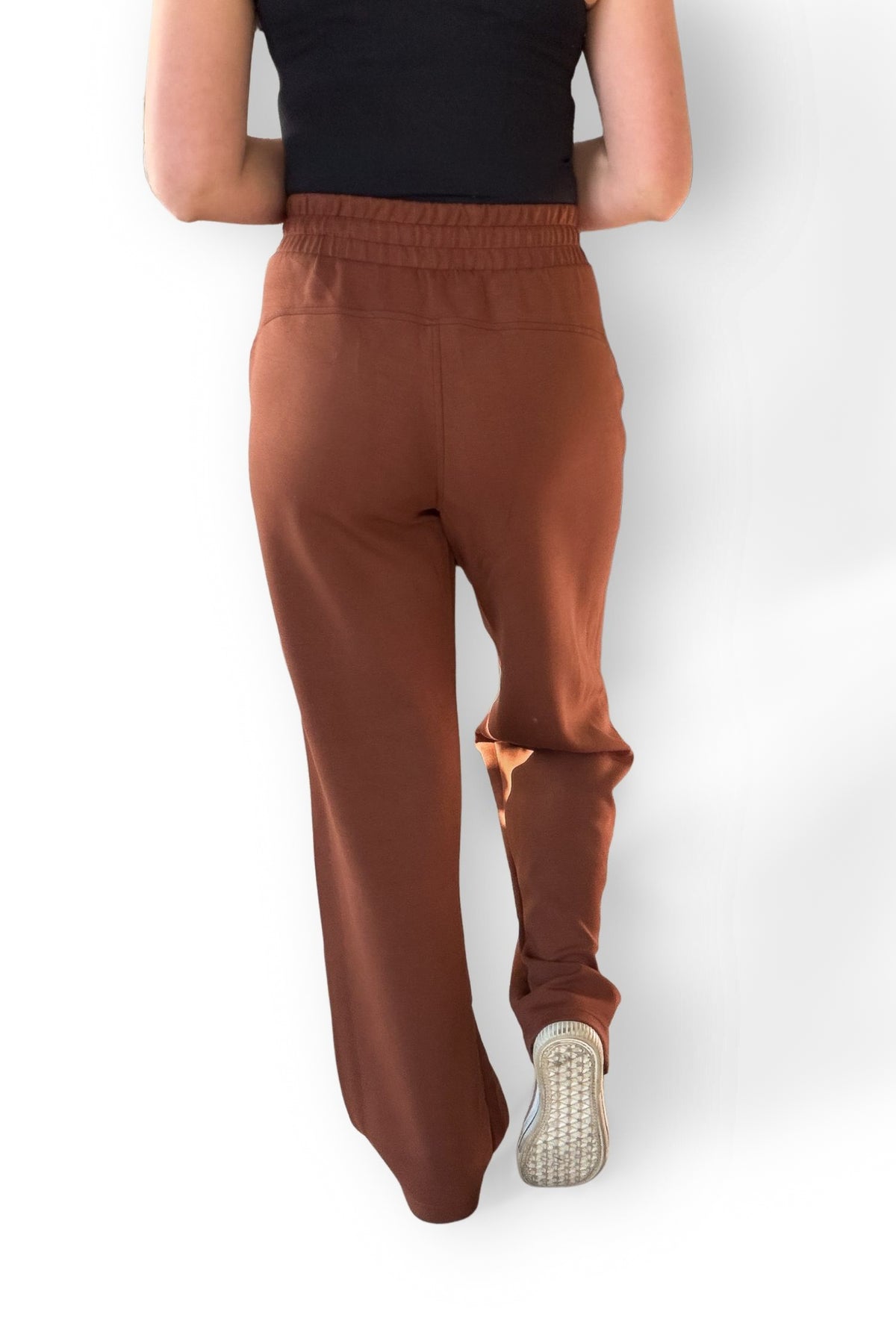 Chestnut scuba strait pants worn by a person on a white background