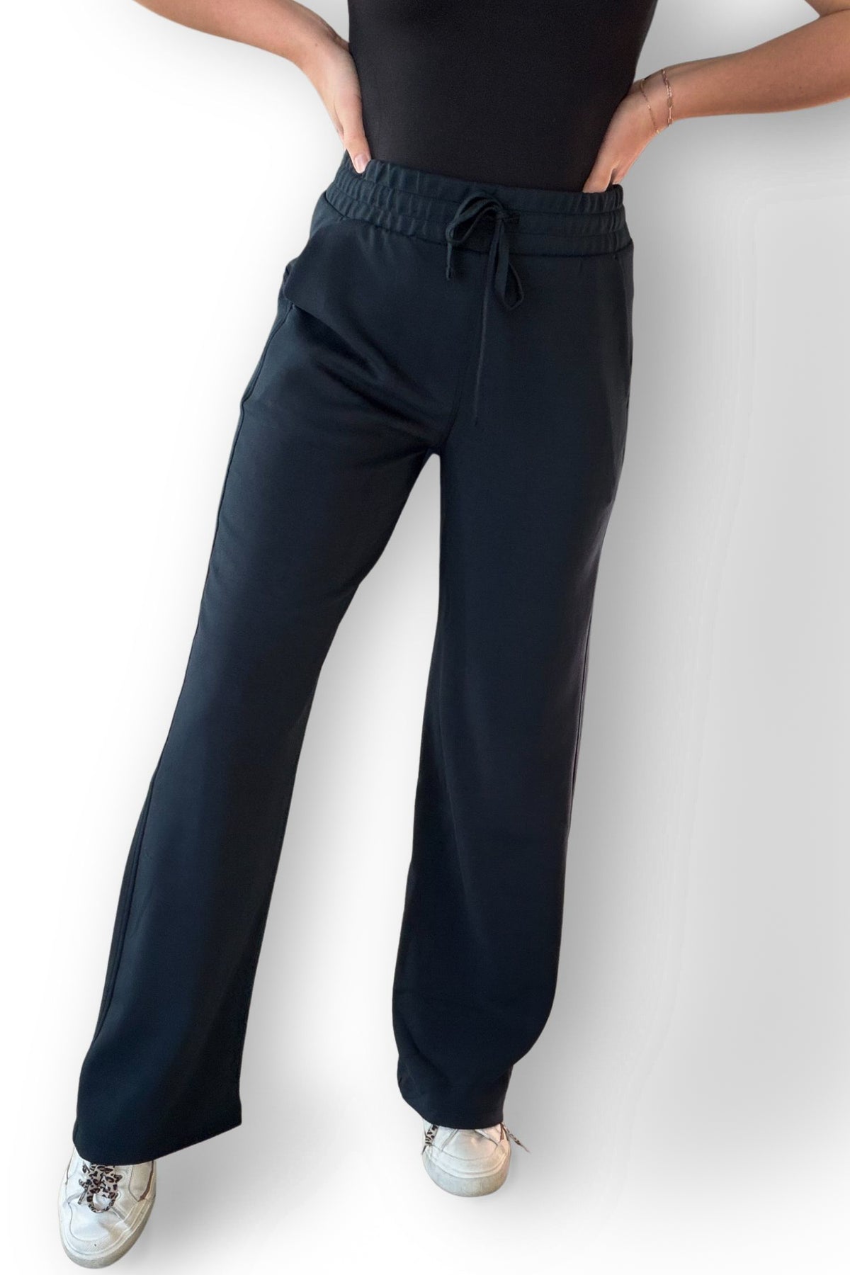 Woman wearing navy scuba material pants 