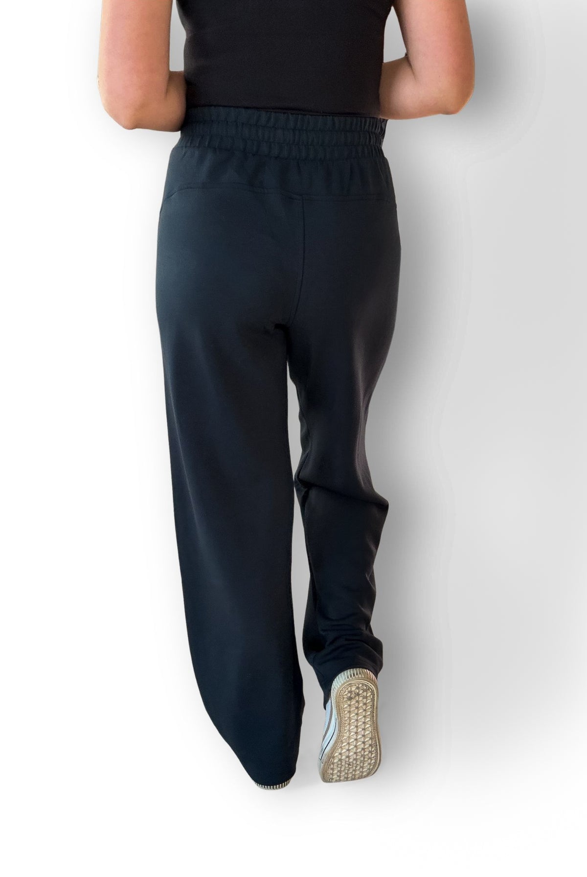 Woman wearing navy scuba material pants showing the back.