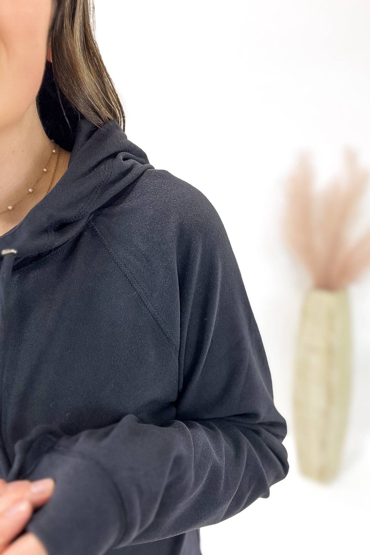 Person wearing a charcoal hoodie with a blurred background