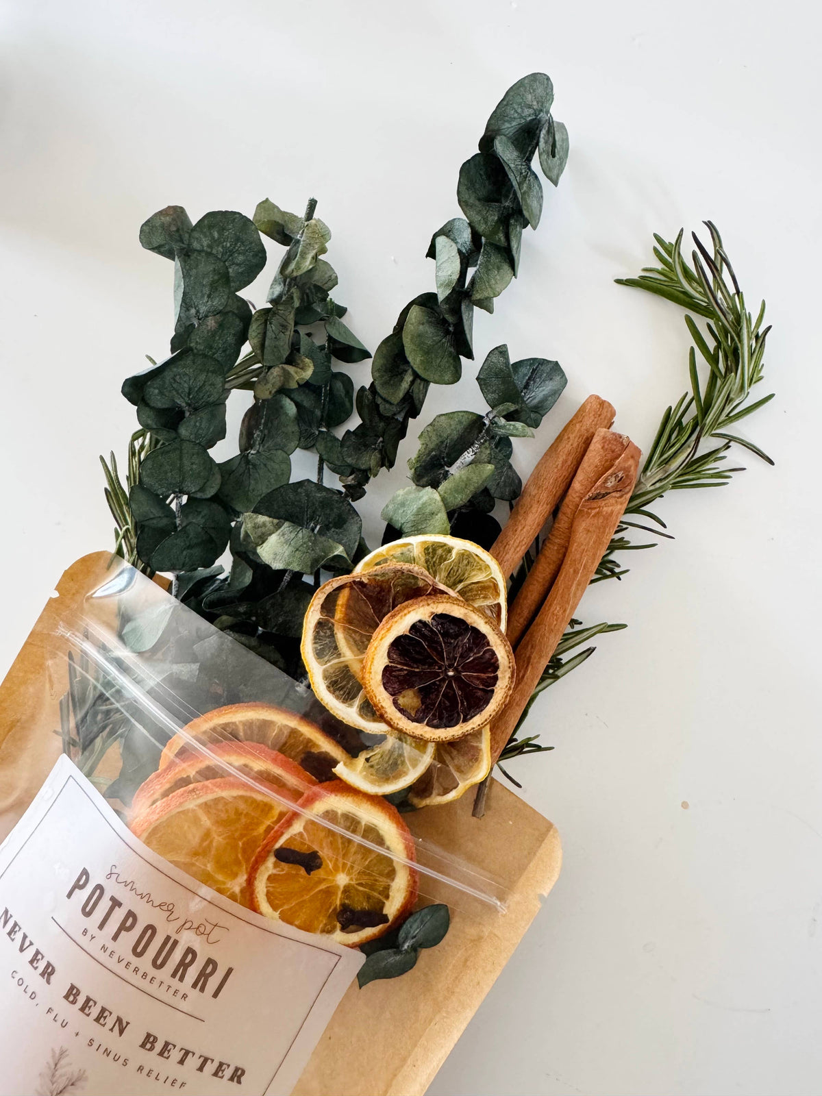 Herbal potpourri with dried oranges, cinnamon sticks, and rosemary on a white background