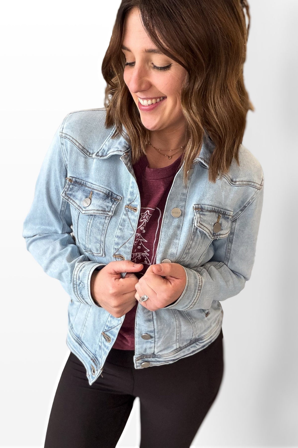 Woman wearing a light blue denim jacket on a white background