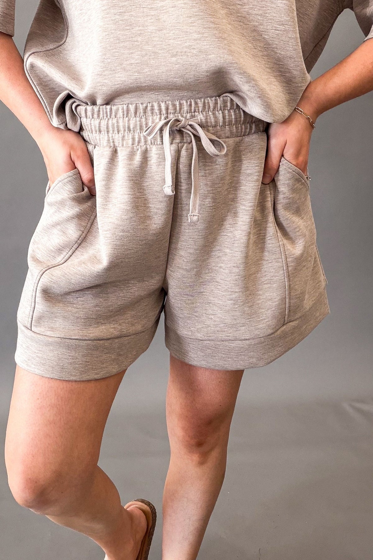 woman wearing comfortable taupe casual shorts with side pockets and drawstring