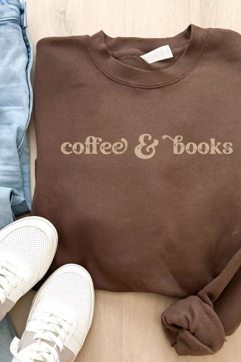 Brown sweatshirt with 'coffee & books' text on a wooden floor.
