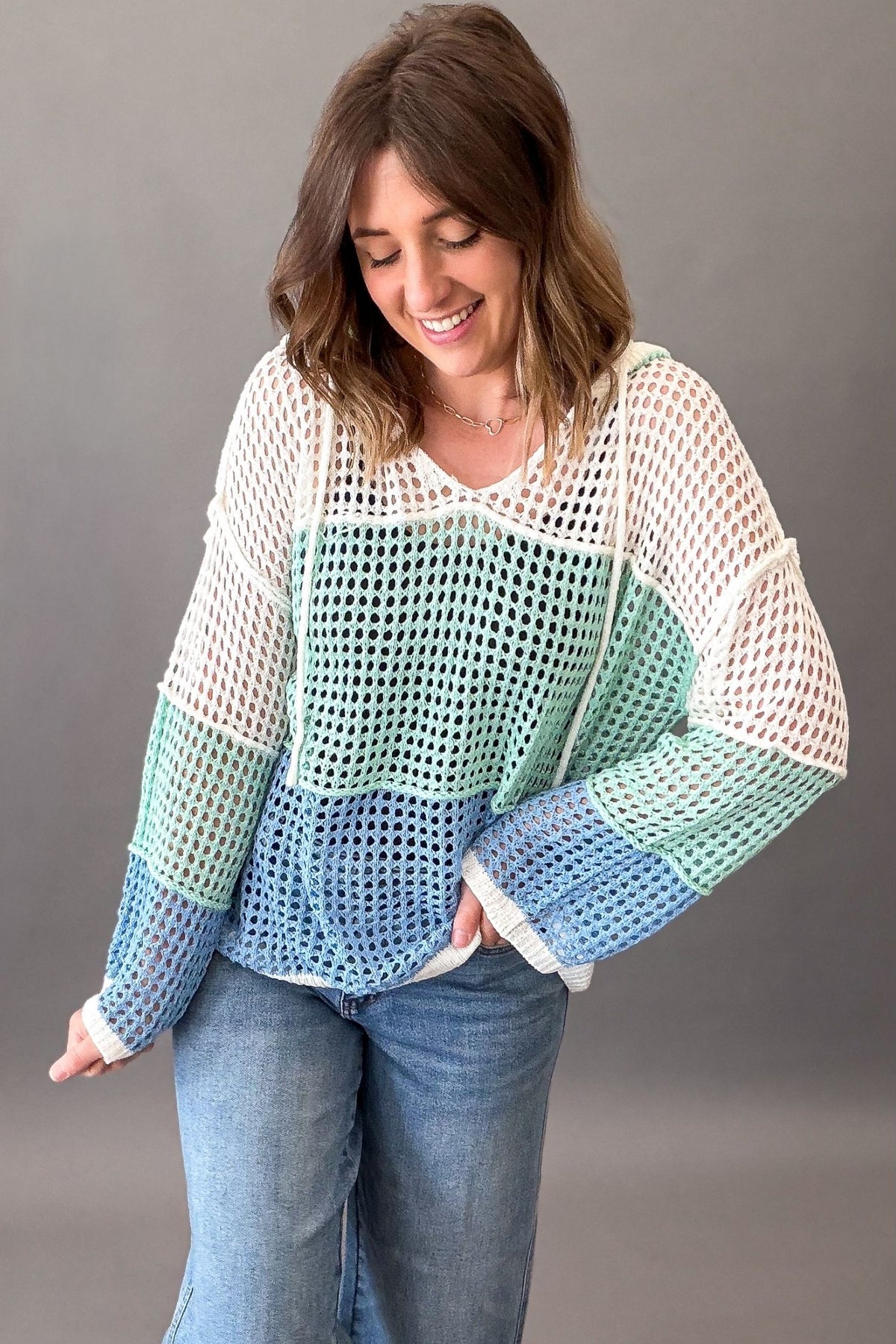 woman wearing a summer layering colorblock sweater and blue jeans
