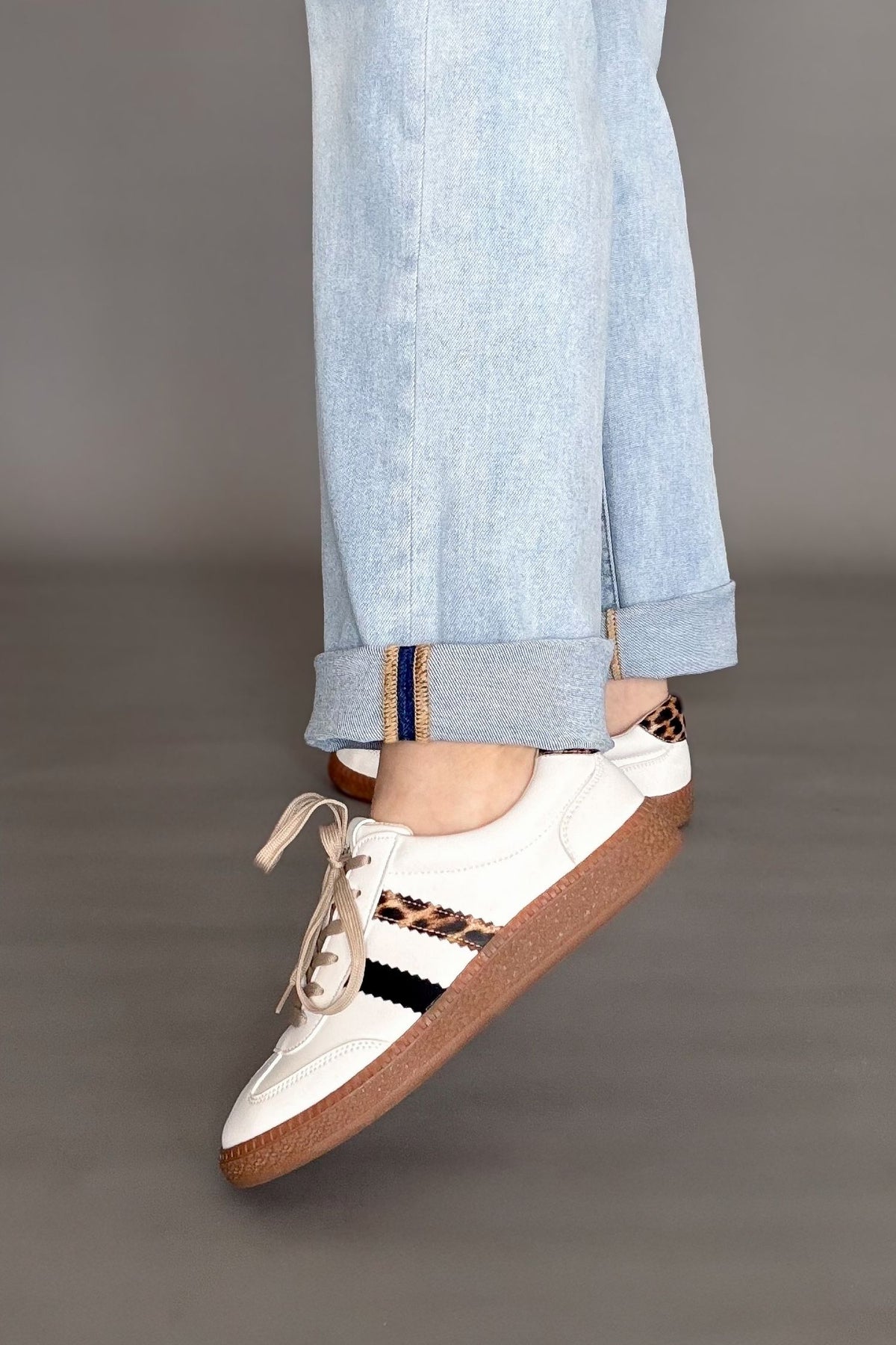 Corkys heads up white sneaker with a leopard and black stripe on the sides. Tan laces