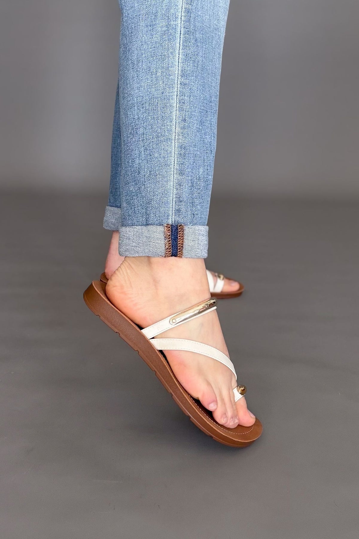 woman wearing corkys hit the strip white sandal with blue jeans