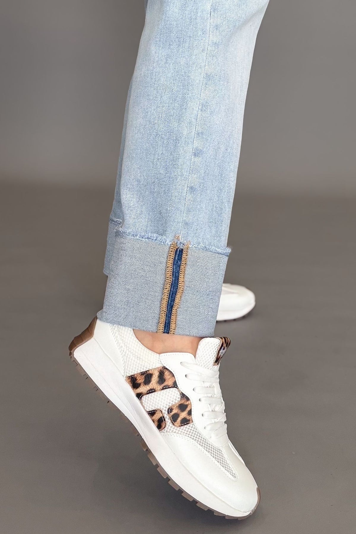 White Corkys No Prob sneakers with leopard print detail styled with light wash denim.