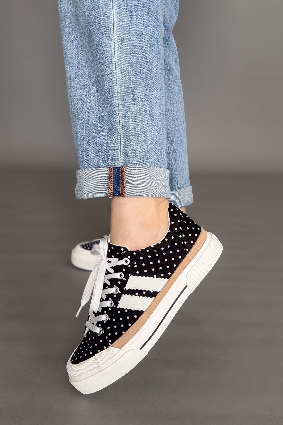 Black polka dot Corkys sneakers with cushioned sole and lace-up front.