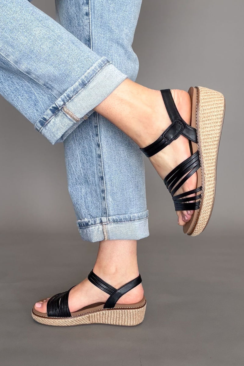 Comfortable black wedge sandals styled with denim