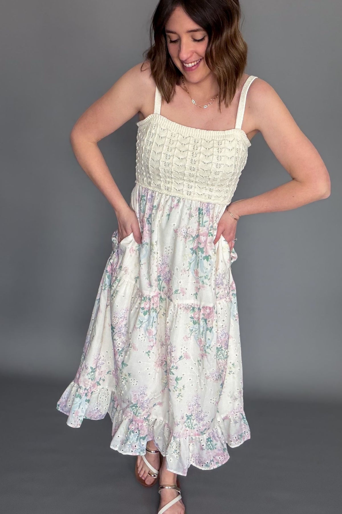 Crochet bodice floral midi dress with adjustable straps and tiered ruffle skirt showing pockets
