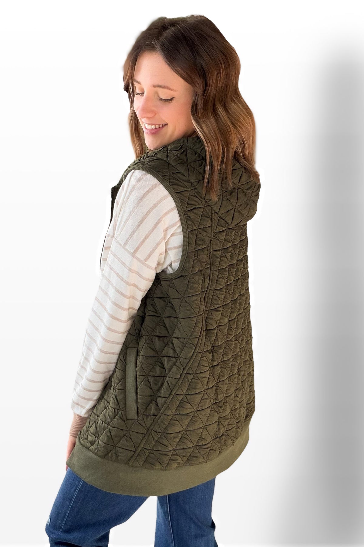 Woman wearing a quilted green vest on a white background