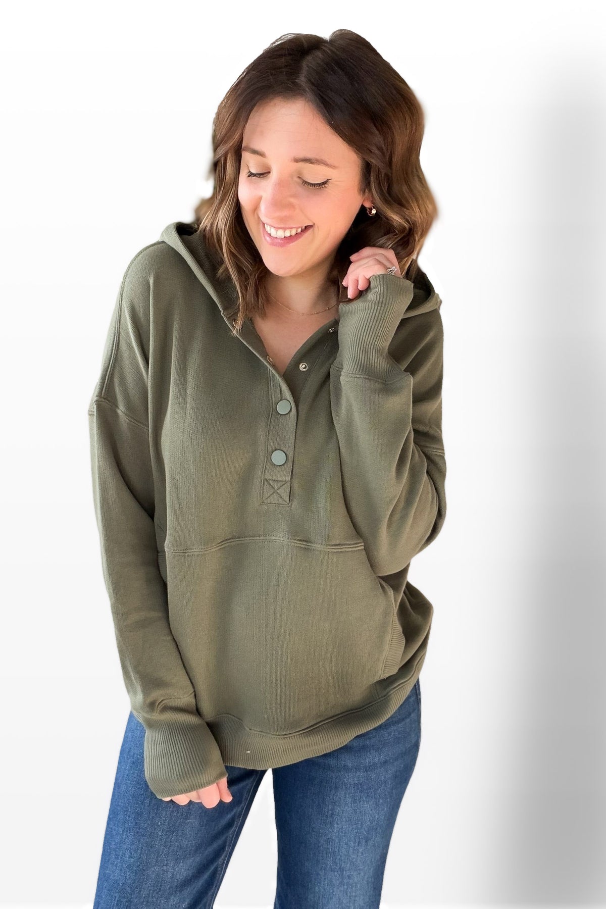 Woman wearing an olive green pullover with a white background