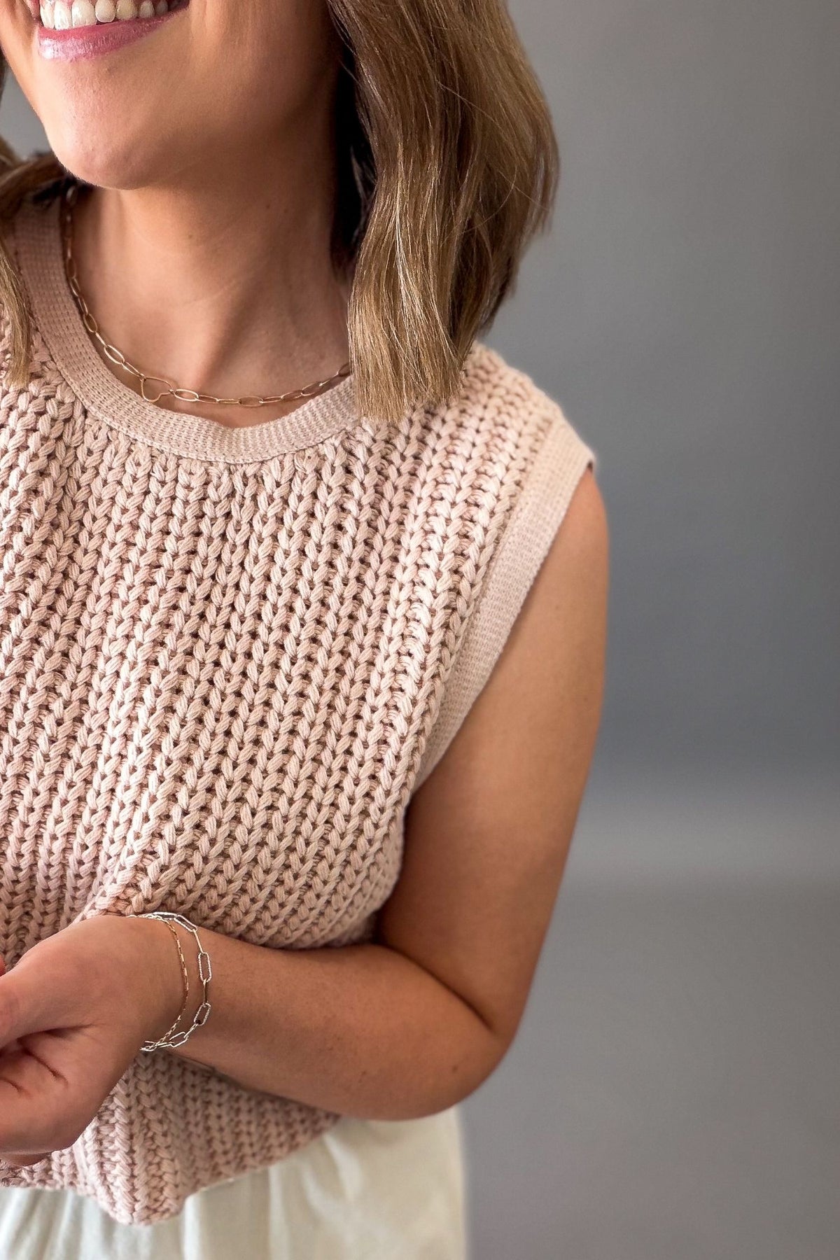 Woman wearing a dusty blush chunky sweater twofer midi dress showing close-up details