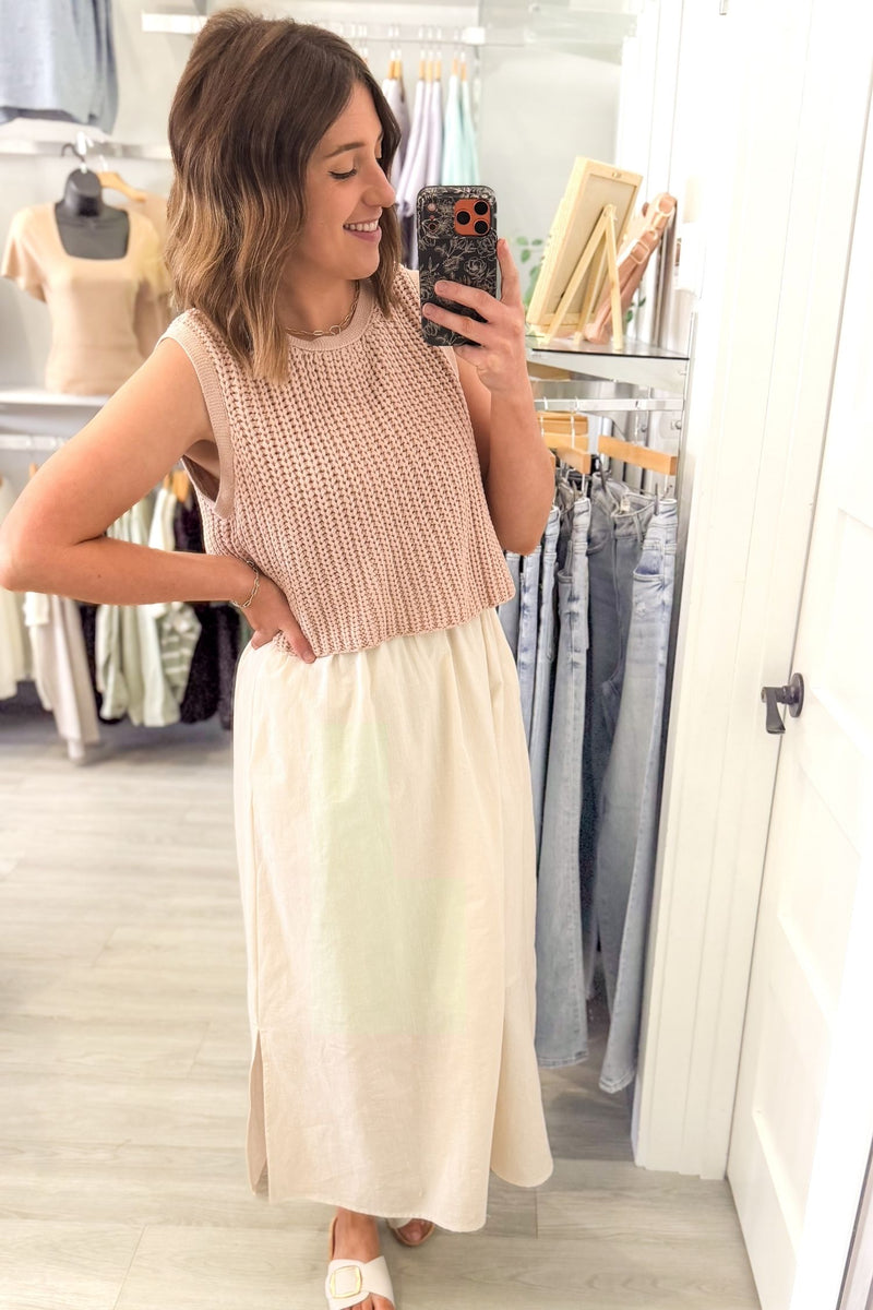 Woman wearing a dusty blush chunky sweater twofer midi dress with layered knit top and flowy lined skirt with side slits