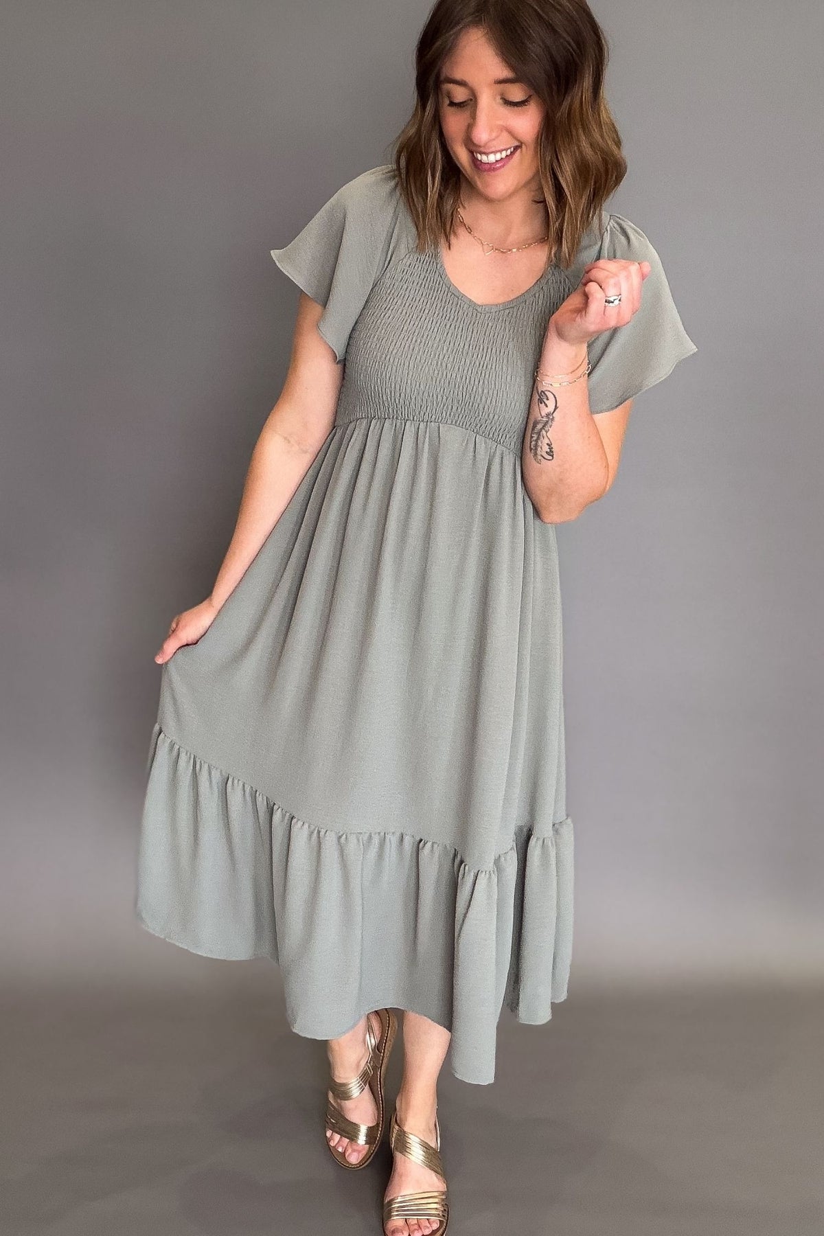 Woman wearing a green dress against a gray background