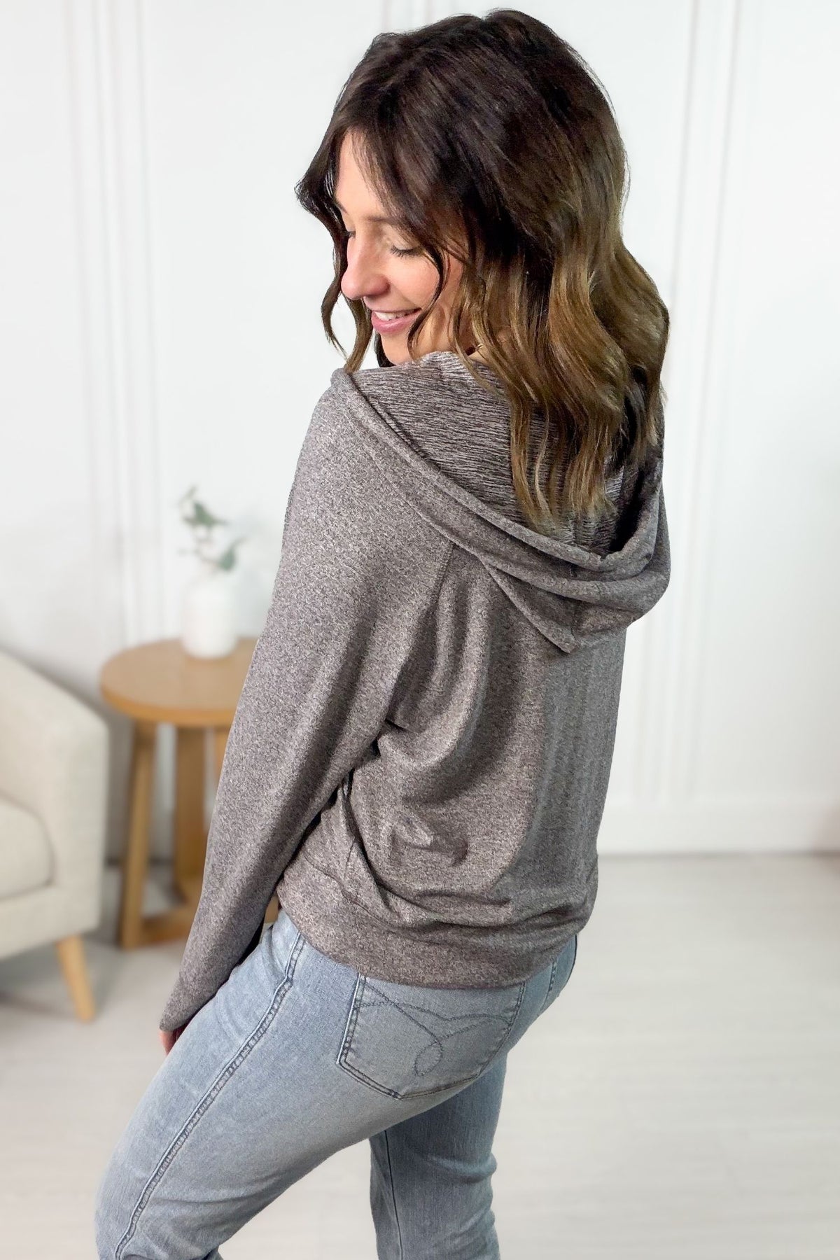 Woman wearing a mocha pullover hoodie in a minimalistic room