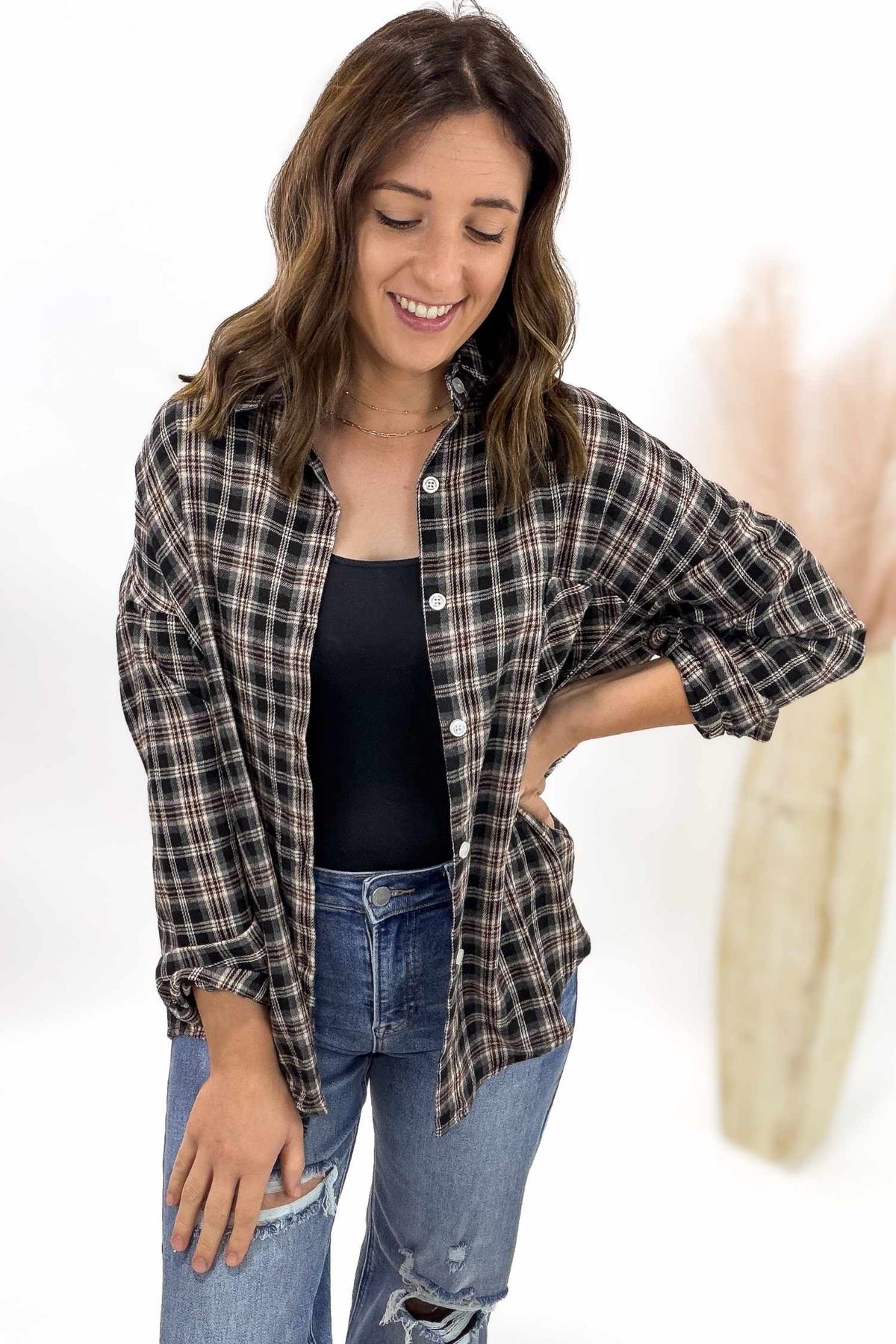 Woman wearing a plaid shirt and jeans on a white background
