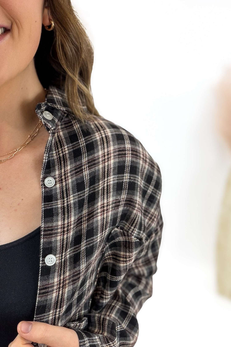 Person wearing a plaid shirt with a blurred background
