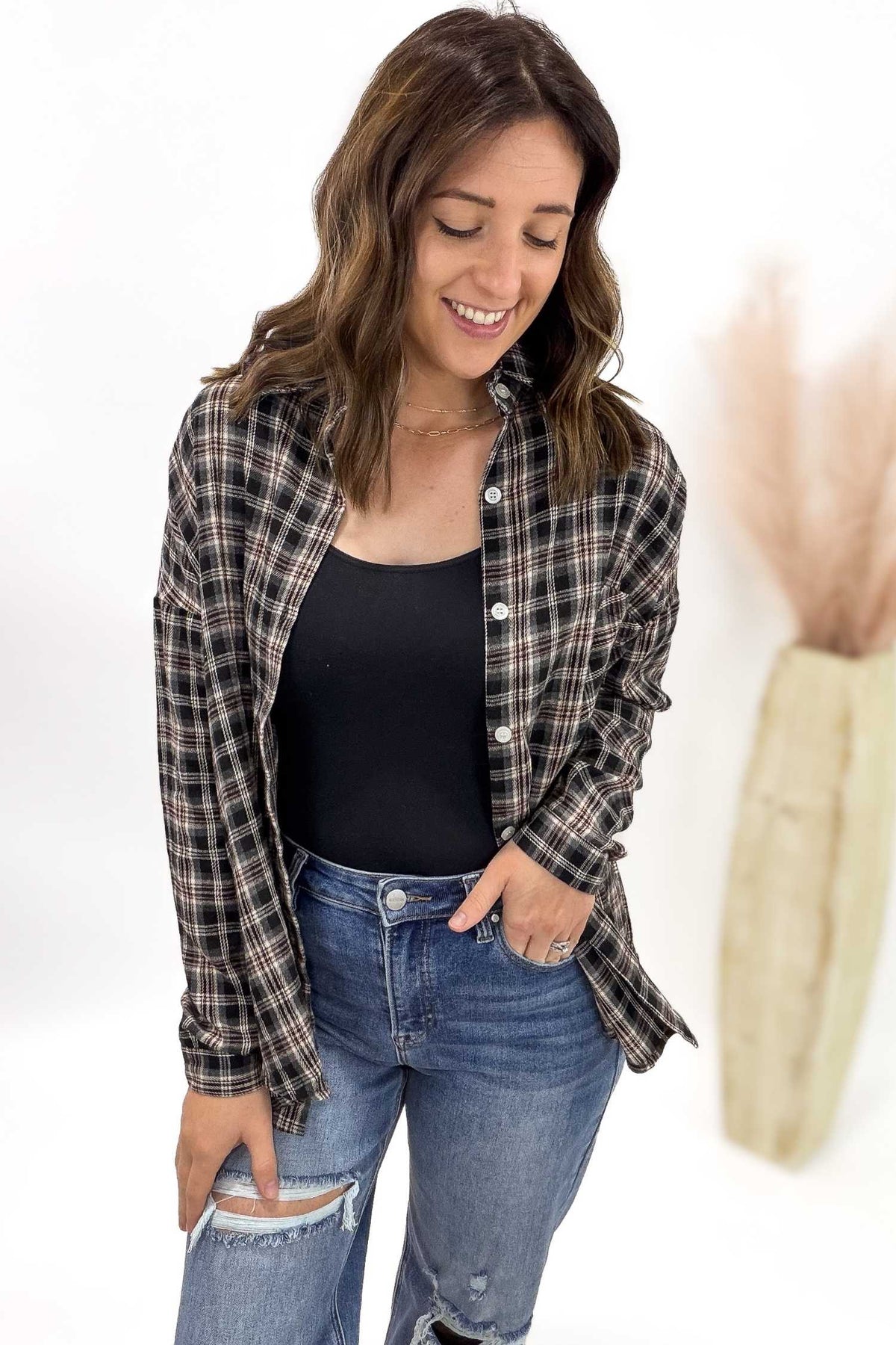 Woman wearing a plaid shirt and jeans with a white background