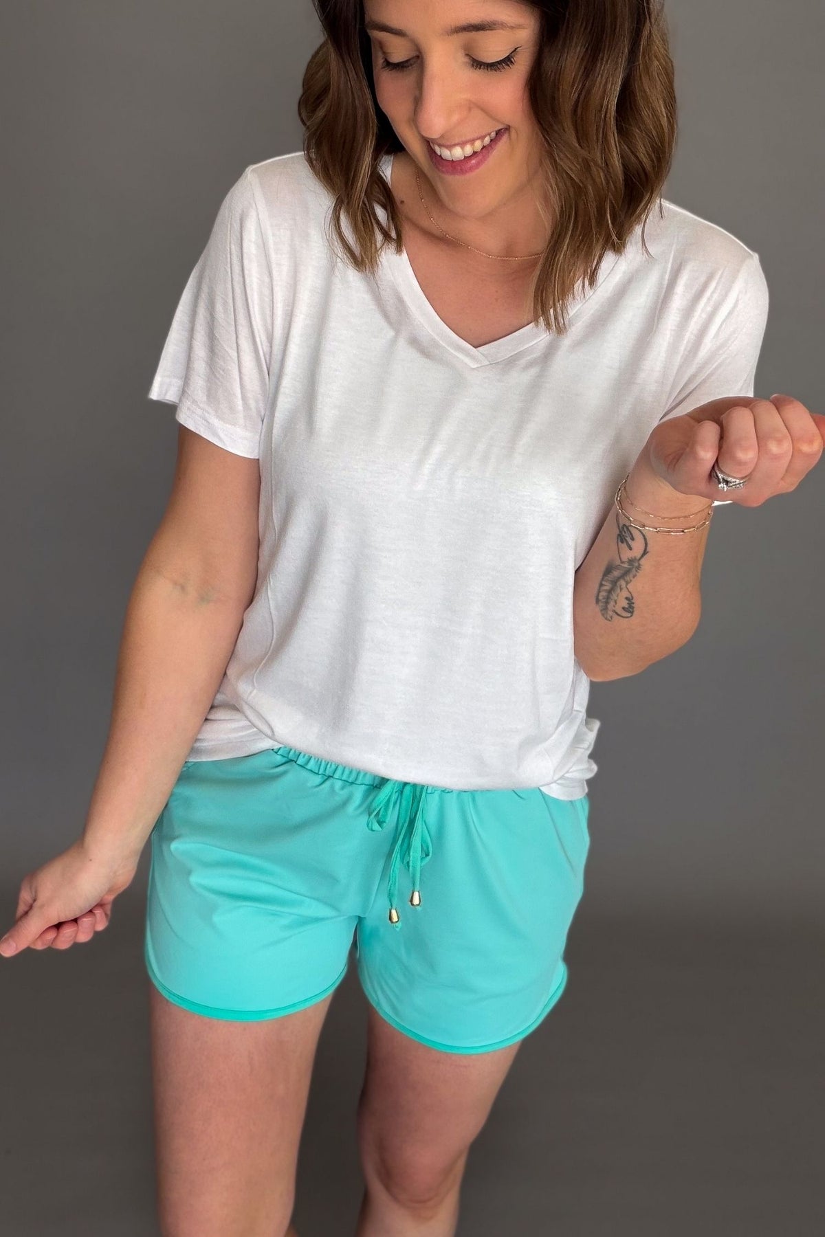 White lightweight v-neck tee styled with aqua drawstring shorts.