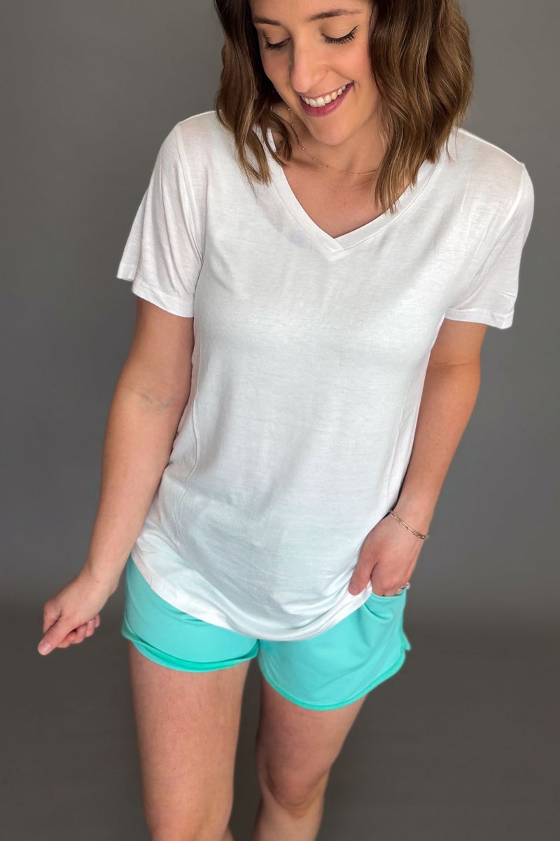 White lightweight v-neck tee styled with aqua drawstring shorts.