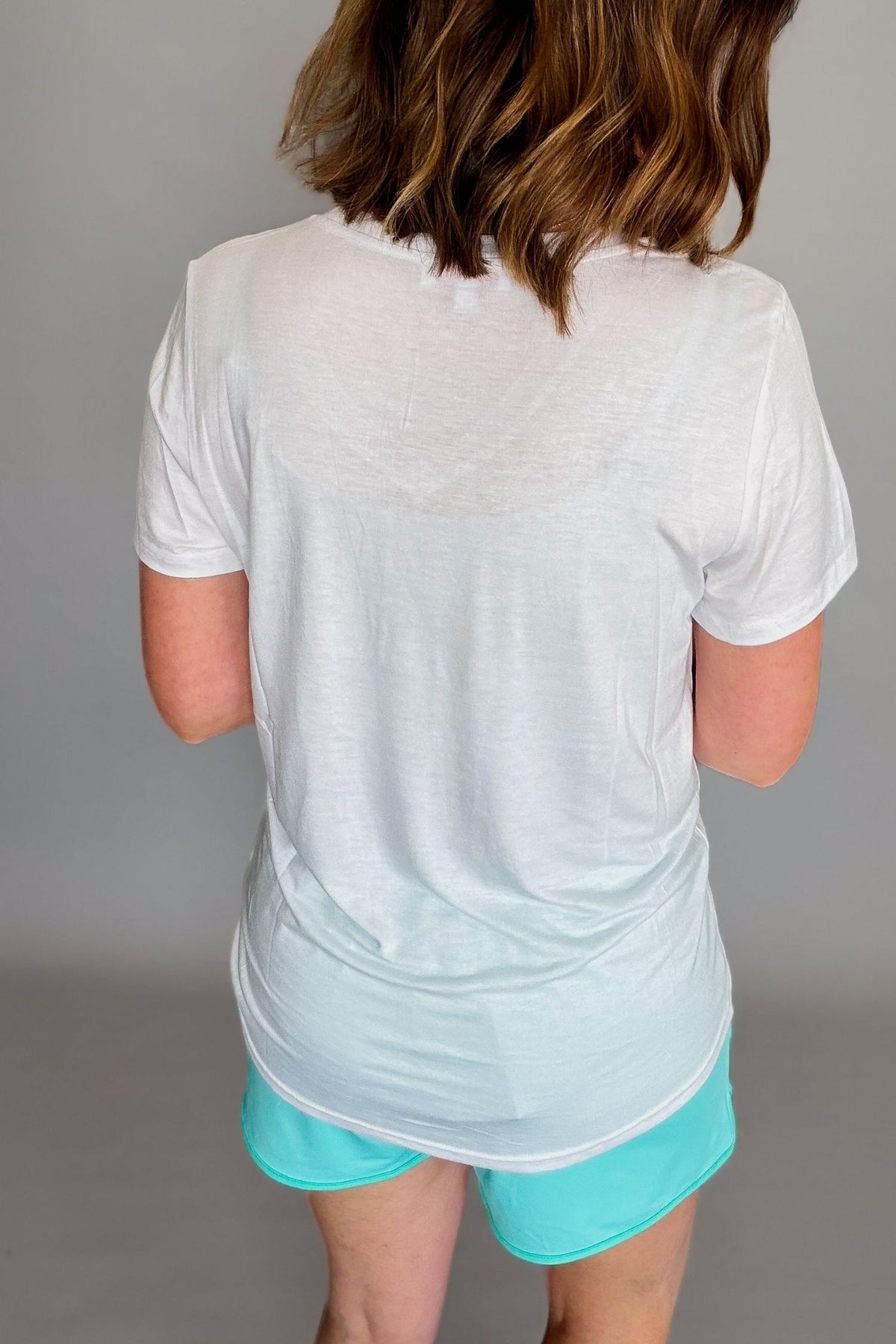 White lightweight v-neck tee styled with aqua drawstring shorts.